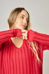 Sweater de punto negro con escote en V y rayas verticales plateadas.