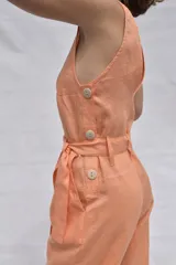 Mono color salmón de lino, con escote en V, sin mangas, con botones frontales y cinturón con lazo.