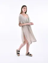 Vestido gris claro de corte suelto, con cinturilla ajustable y mangas amplias.