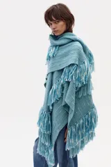 Ruana tejida en lana merino color celeste con flecos.