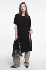 Vestido negro tipo túnica, de corte recto y largo midi, con mangas cortas y aberturas laterales.