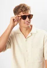Gafas de sol Eco Shades Fontana con montura redonda gris y lentes verdes. Fabricadas con acetato biodegradable y lentes de PMMA reciclado.