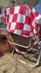 Bolso de playa convertible en toalla, con estampado de cuadros grandes en blanco y azul.