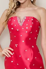 Vestido corto de fiesta strapless color fucsia, con escote recto y corte ajustado. Adornado con pedrería plateada en el escote y dispersa por todo el vestido.