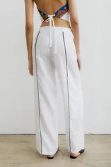 Pantalón recto color crema de lino con costuras laterales en negro.