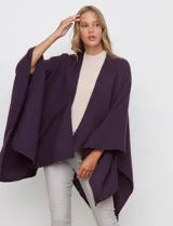 Ruana de tejido suave color morado oscuro, con cuello redondo y corte amplio tipo capa.