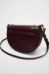 Bolso de hombro ovalado negro con asa de doble tira redonda con detalles metalizados dorados. Cierre imantado y asa de bandolera extraíble con tejido a contraste. Bolso interior con cierre mediante cremallera metálica.