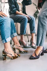 Zapatos de tacón con estampado animal print en tonos marrón, blanco y negro. Tienen punta fina, pulsera con hebilla lateral y tacón ancho. Interior de piel y suela de cuero.