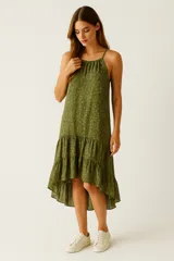 Vestido verde con estampado floral, breteles finos, corte asimétrico y volados en el ruedo.