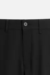 Pantalón slim fit negro confeccionado en tejido con elasticidad en ambas direcciones. Cuenta con bolsillos frontales y traseros de vivo con botón. Cierre frontal con cremallera y botón.