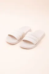 Sandalias tipo slipper color beige con tira ancha acolchada.