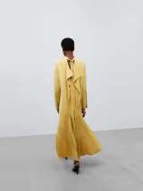 Vestido largo amarillo de viscosa con cuello mao, corte recto y abertura lateral.