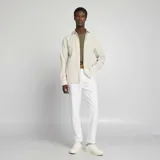 Camisa beige con rayas verticales finas, de corte clásico, manga larga y cuello camisero.