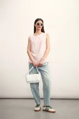 Blusa color crema sin mangas, de lino, con cuello redondo y corte recto.