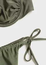 Conjunto de bikini verde militar con corpiño bandeau con aro y detalle fruncido, y bombacha colaless con tiras laterales ajustables.