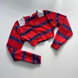 Remera corta de manga larga, con cuello polo y rayas horizontales rojas y azules.