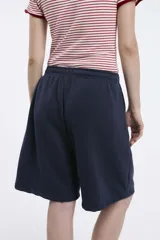 Short deportivo negro con cintura elástica y bolsillos laterales. Corte holgado a la rodilla.