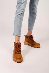 Borcegos marrones de cuero con textura símil cocodrilo, caña media con detalle de gamuza en la parte superior, cordones marrones y suela track.
