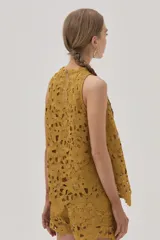 Short de guipur floreado color mostaza, confeccionado en tela especial que aporta textura y sofisticación.