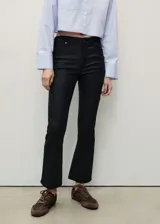 Pantalón de jeans negro con efecto encerado, tiro medio, corte bootcut y largo cropped.