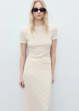 Falda midi color crudo, de tejido texturizado con diseño entallado y cintura elástica.