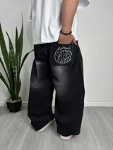 Pantalón baggy negro con efecto lavado y bordado blanco en el bolsillo trasero.