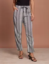 Pantalón largo de lino y rayón a rayas verticales grises y blancas. Tiene pretina elastizada con lazo de ajuste, bolsillos delanteros y traseros.