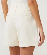 Short corto color marrón, de tiro medio, con cinturón de la misma tela y bolsillos laterales.