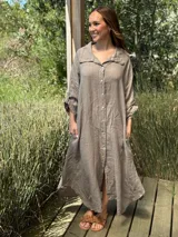 Vestido camisero amplio y largo de lino color azul, con botones de nácar, cuello camisero y bolsillos laterales.