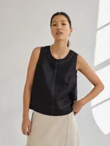 Top color beige de lino y viscosa, corte recto y escote redondo con cierre a la vista en la espalda y pespuntes a contratono.