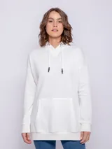 Canguro oversize color blanco en tela deportiva, con capucha y cordones, y bolsillo frontal grande.
