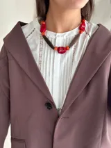 Collar corto con cuentas de resina rojas y naranjas, piedras rojas irregulares y cuentas de madera marrón.