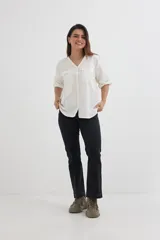 Camisa color crema de algodón con escote en V, mangas 3/4 con trabilla y dos bolsillos con solapa en el pecho.