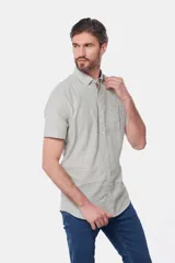 Camisa celeste de lino y algodón, de manga corta, con cuello abotonado y bolsillo en el pecho.