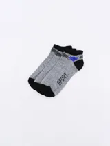 Pack de tres pares de medias deportivas tobilleras, color gris melange, con puño negro y detalles geométricos en gris oscuro y azul. Una de las medias tiene la palabra "SPORT" estampada en el empeine.