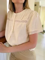 Camisa color amarillo manteca de lino, con cuello a la base, tablitas en el frente y puntilla.