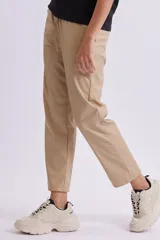 Pantalón de cuero sintético color beige con cintura elástica y cordón ajustable.