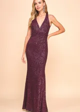 Vestido largo de fiesta color borgoña, cubierto de lentejuelas brillantes, con escote halter profundo y espalda descubierta.