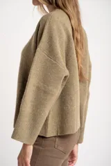 Sweater de punto color tostado con calce oversize, cuello redondo y mangas largas anchas. Presenta terminaciones acanaladas en cuello, puños y ruedo.