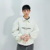 Chaqueta color hueso de denim con cierre frontal, cuello camisero y puños elásticos. Presenta un estampado con el texto "Venefico Company" en el pecho.