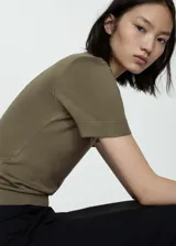 Remera de punto fino color blanco, de manga corta y cuello redondo.