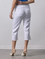 Pantalón capri color rosa de tencel elastizado con bolsillos simulados en la parte delantera y bolsillos aplicados en la parte trasera. Tiene pretina ancha, corte recto y terminación de ruedo desflecado.