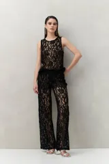 Pantalón ancho de encaje floral negro con transparencias.