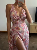 Vestido largo de seda estampada con flores rosas, escote en V con aro y falda con capas diagonales.