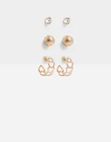 Set de tres pares de aros dorados: un par de aros pasantes con strass, un par de aros pasantes con forma de esfera texturizada y un par de aros argolla con forma de corazones.