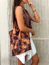 Bolso tote de tela con estampado batik en tonos marrones y naranjas.