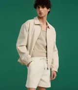 Bermuda de terciopelo color crema, corte runner, con cintura elástica, cordón ajustable y bolsillos laterales.