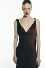 Vestido midi marrón de satén, con escote fluido, tirantes finos y espalda descubierta con lazo.