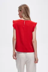 Blusa roja de poliéster con cuello a la base y volados en los hombros.