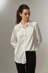 Camisa blanca de manga larga con botones frontales y diseño clásico.